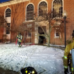 Firefighters clean up equipment after fighting a fire at the library
