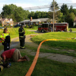 Firefighters check the tailboard of 28-13 at the garage fire on Star Route