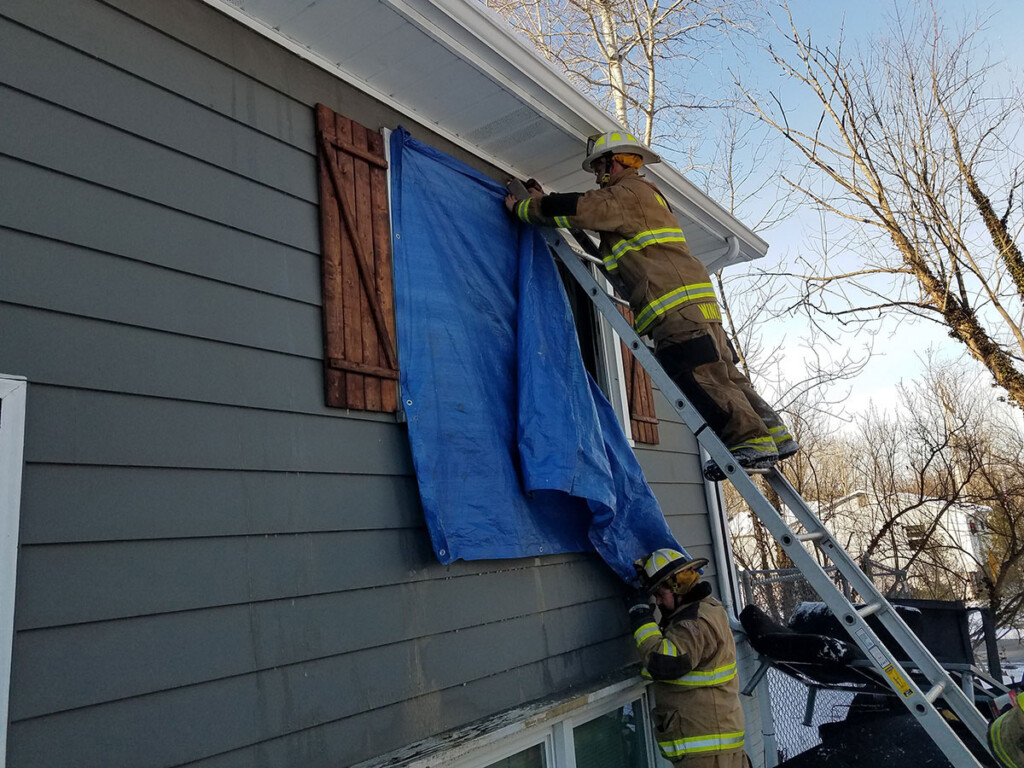 Lt Dallas Winckler and Asst Chief Terry Shaulis complete salvage operations by sealing up a broken window