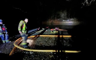 Firefighter Dale Johnston works on portable pumps to provide water supply