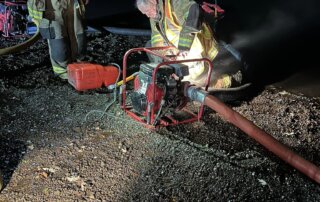 Firefighters Dale Johnston and Andrew Munshower work on portable pumps to provide water supply