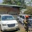 firefighters inspect a vehicle that was recently on fire near a garage